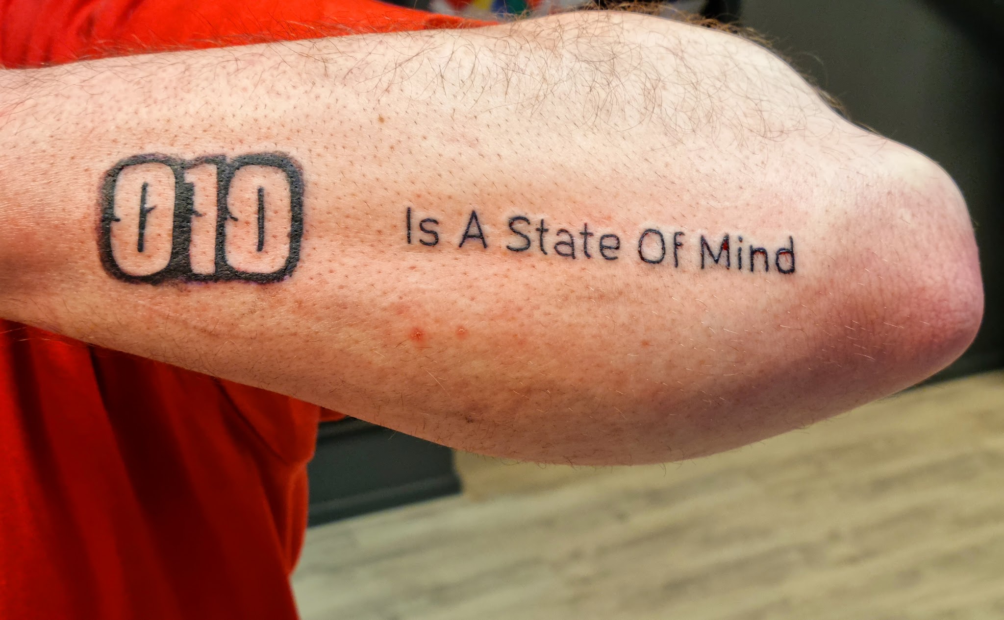 Lettering-tattoo op een onderarm: 010 Is A State Of Mind